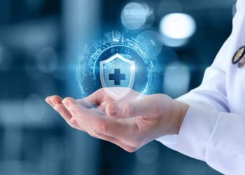 The doctor shows the icon of the protection of health on blurred background. The doctor shows the icon of the protection of health on blurred background.